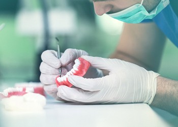 A lab technician creating a custom-made denture for a patient