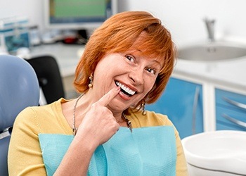 Older woman pointing to smile