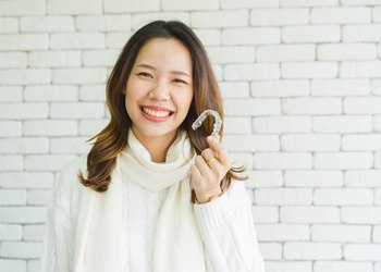 woman holding clear correct aligner