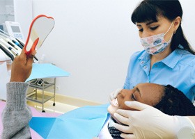 Woman in dentist’s chair looking in mirror