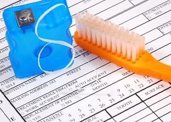 Toothbrush and floss on dental insurance form