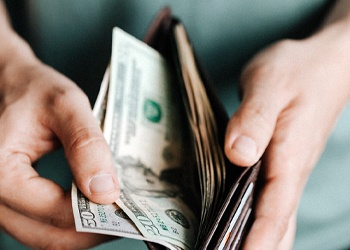 Man with cash holding open wallet