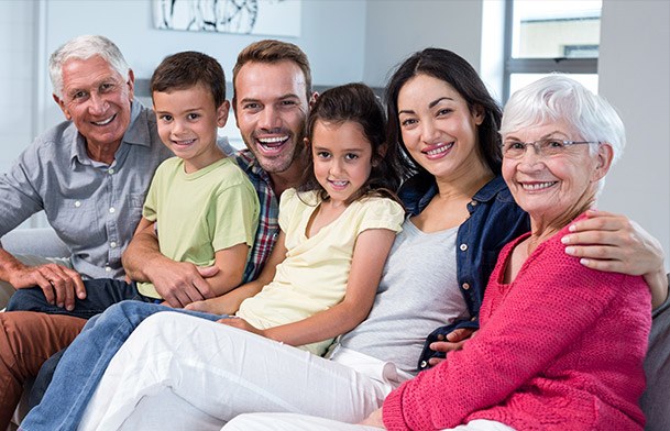 Three generations of family smiling in dental office