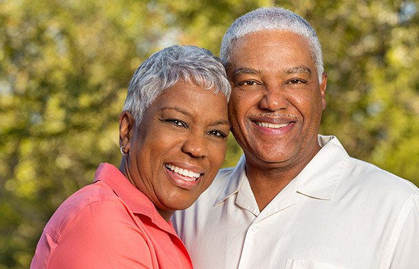 Older man and woman smiling outdoors