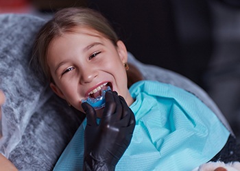 a young girl trying on her sportsguard in a dental office