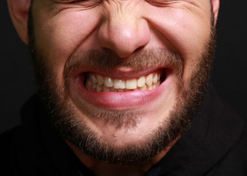 An upset man grinding his teeth and clenching his jaw