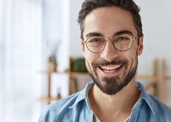 a man with glasses smiling