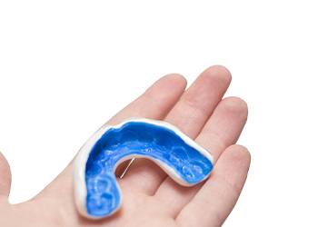 A person holding a custom-made mouthguard