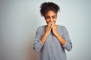 person hiding their smile behind their hands