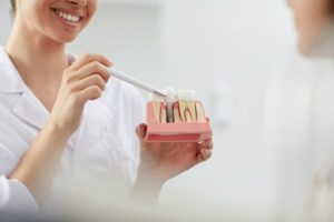 dentist explaining dental implants model
