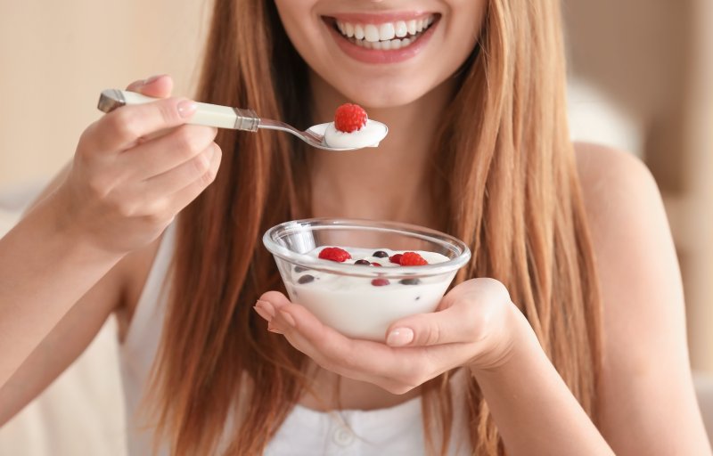 Woman eating yogurt after dental implant surgery