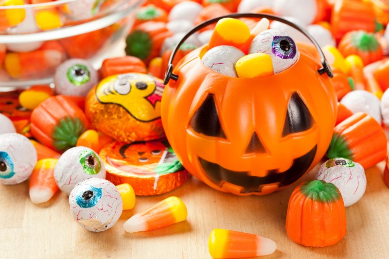 Tiny trick-or-treat bucket surrounded by candy