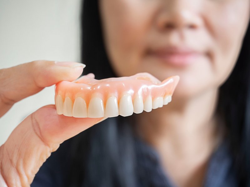 a woman in Crown Point holding her dentures 