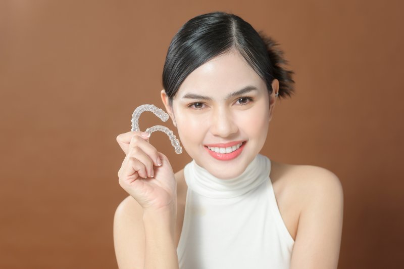Smiling lady shows off ClearCorrect aligner