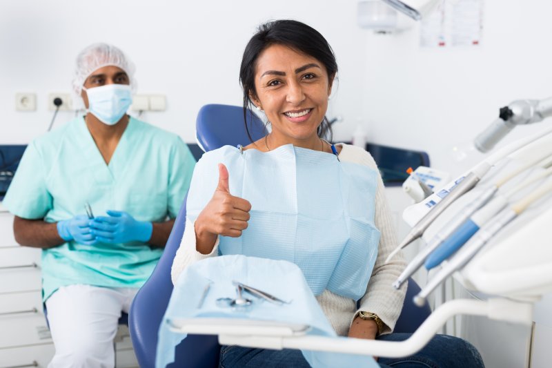 Patient giving thumbs up with cosmetic dentist